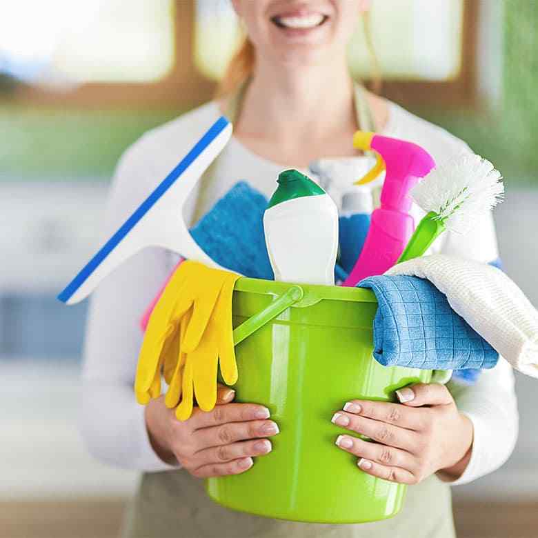 Smiling cleaner holding a bucket of supplies for house cleaning in Kenmore WA