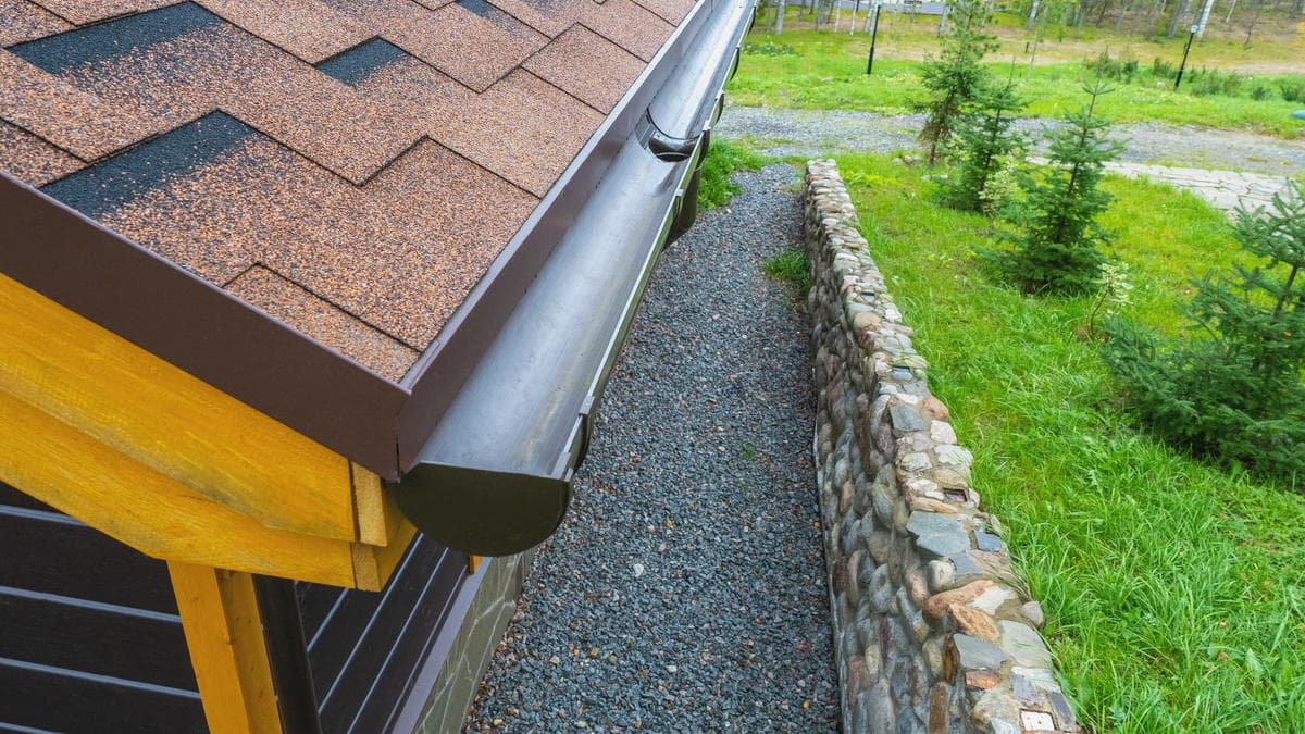 clearing clogged gutter and flushing downspout on a Kirkland home