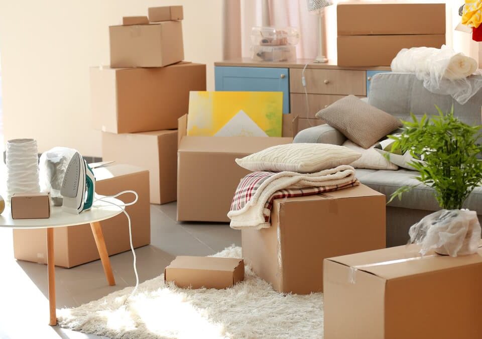Room filled with moving boxes, a sofa, and a table. Ideal for Kirkland House Cleaners' post-move cleaning services.